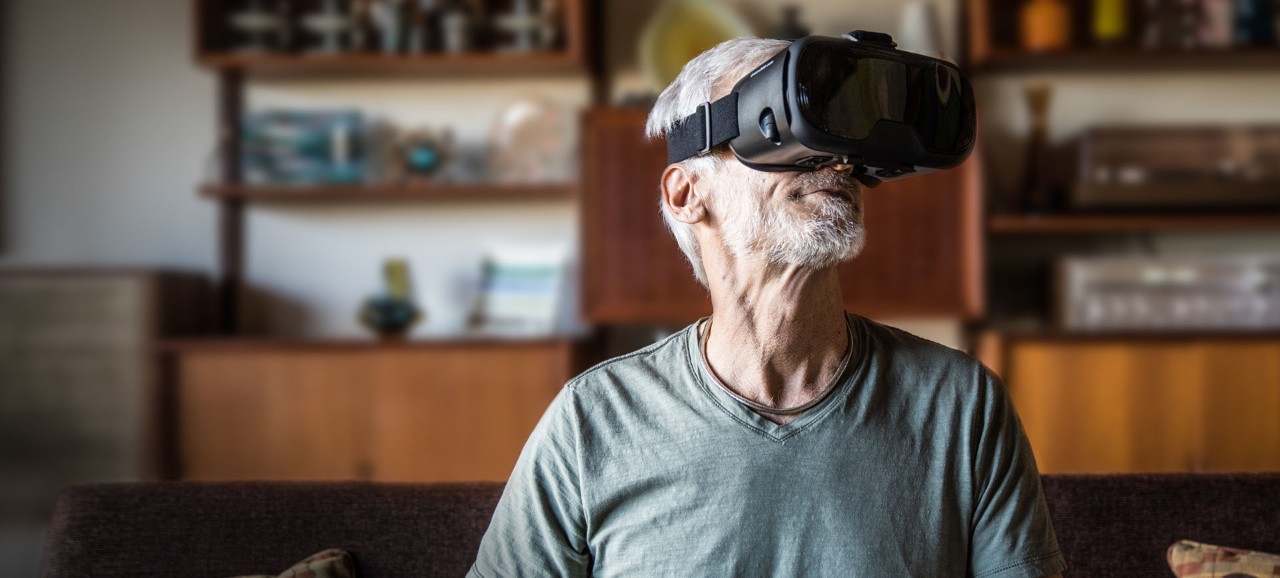 一个戴着虚拟现实耳机抬头的老人