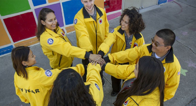 穿着黄色夹克的人们双手紧握成一个圈