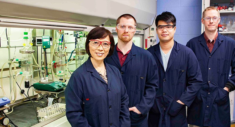 镜风的四名科学家和蓝色制服的四个科学家站立
